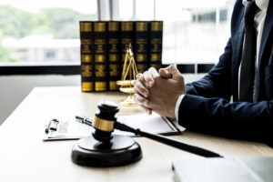 Lawyer sitting in a chair with a contract and a gavel in front of him.