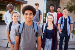 Portrait Of High School Students With Teacher Outside College Bu